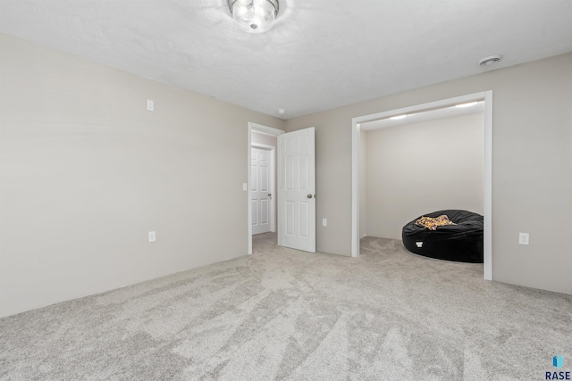 unfurnished bedroom featuring carpet floors and a textured ceiling