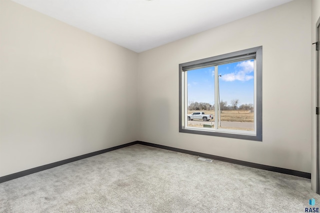 spare room with visible vents, carpet, and baseboards