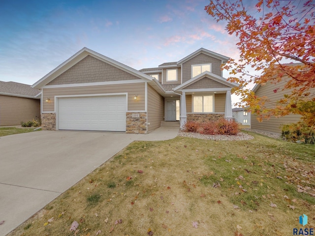 204 E 81st Pl, Sioux Falls, SD 57108 - craftsman-style house with stone siding, an attached garage, concrete driveway, and a yard