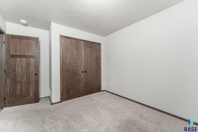 204 E 81st Pl, Sioux Falls, SD 57108 - unfurnished bedroom with a closet, baseboards, a textured ceiling, and carpet