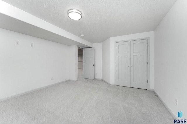 204 E 81st Pl, Sioux Falls, SD 57108 - unfurnished bedroom featuring light carpet, baseboards, a textured ceiling, and a closet