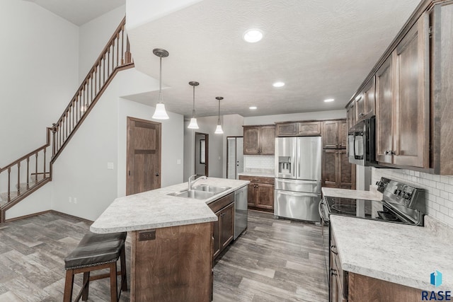 204 E 81st Pl, Sioux Falls, SD 57108 - kitchen with dark wood-style floors, stainless steel appliances, an island with sink, and a sink