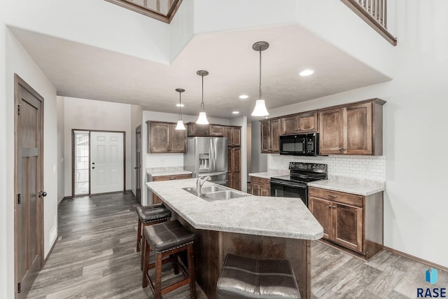 204 E 81st Pl, Sioux Falls, SD 57108 - kitchen with black appliances, wood finished floors, light countertops, and a sink