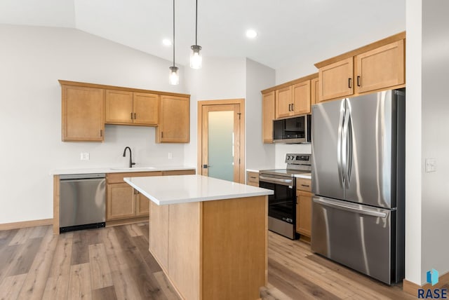kitchen with lofted ceiling, appliances with stainless steel finishes, wood finished floors, and light countertops