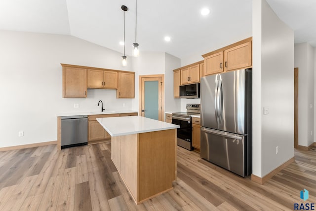 kitchen with light wood finished floors, stainless steel appliances, light countertops, and a sink