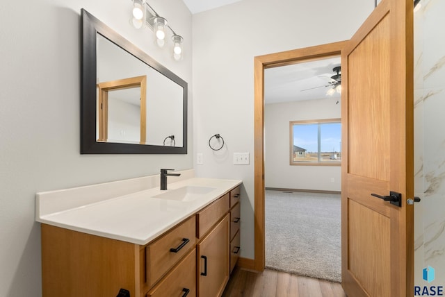 bathroom featuring baseboards, vanity, ceiling fan, and wood finished floors