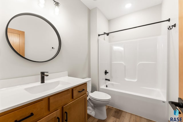 bathroom with toilet, vanity, bathing tub / shower combination, and wood finished floors