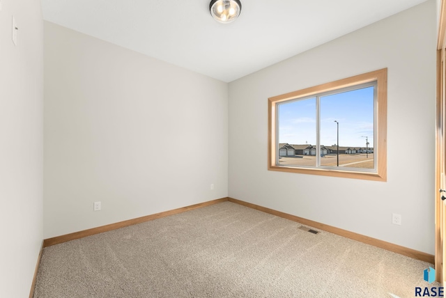 spare room featuring visible vents, carpet flooring, and baseboards