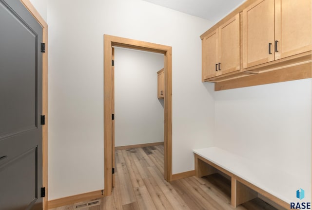 mudroom featuring visible vents, baseboards, and light wood-style floors
