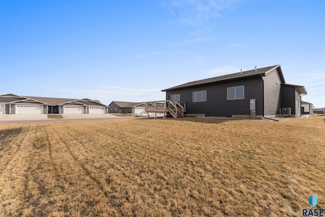 exterior space featuring a residential view, a lawn, driveway, and a garage
