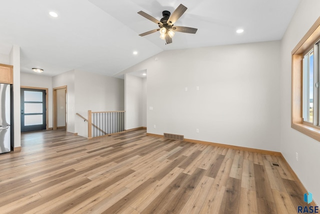 spare room with visible vents, light wood-style flooring, a ceiling fan, baseboards, and lofted ceiling