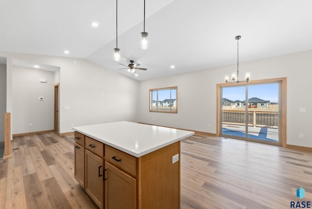 kitchen with plenty of natural light, lofted ceiling, light wood-style flooring, and open floor plan