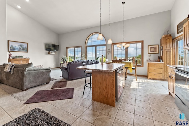 6305 Lakeview Dr, Wentworth, SD 57075 - kitchen with high vaulted ceiling, an inviting chandelier, stainless steel electric range, a kitchen breakfast bar, and open floor plan