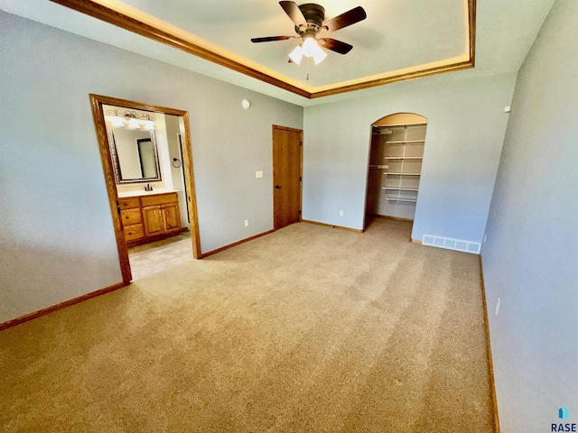 800 W Sterling Oak Cir, Sioux Falls, SD 57108 - unfurnished bedroom with arched walkways, a raised ceiling, light colored carpet, ensuite bath, and a closet