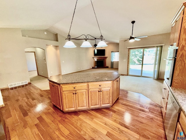 800 W Sterling Oak Cir, Sioux Falls, SD 57108 - kitchen with arched walkways, light wood-style floors, appliances with stainless steel finishes, open floor plan, and a fireplace with raised hearth