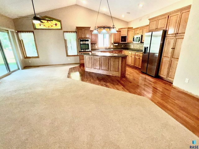800 W Sterling Oak Cir, Sioux Falls, SD 57108 - kitchen featuring stainless steel appliances, carpet floors, a center island, open floor plan, and dark countertops