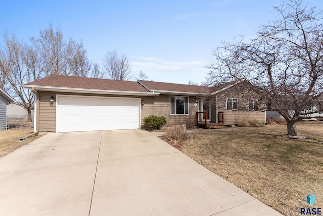 ranch-style house featuring an attached garage, a shingled roof, driveway, and a front lawn
