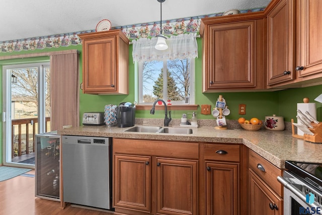 kitchen featuring a sink, plenty of natural light, brown cabinetry, and stainless steel appliances