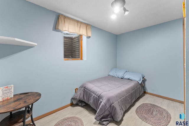 bedroom featuring baseboards and wood finished floors