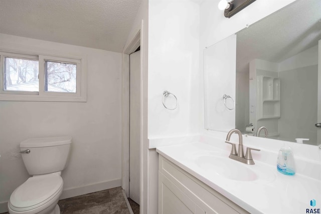 full bath featuring toilet, a textured ceiling, vanity, and baseboards