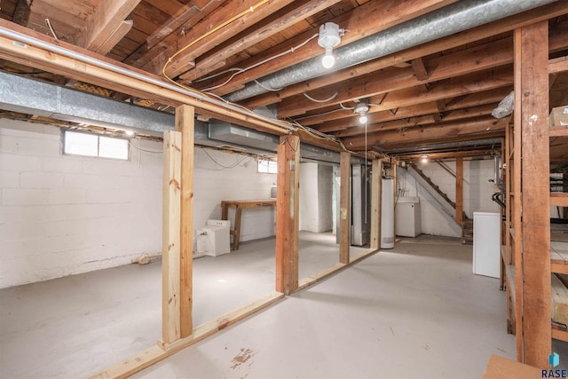 below grade area featuring gas water heater, stairway, and separate washer and dryer
