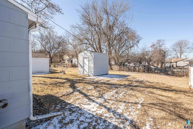 view of yard featuring an outdoor structure, fence, and a shed