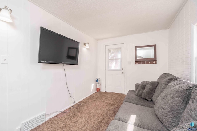 living room with visible vents, carpet floors, and a textured ceiling