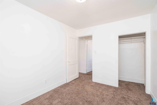 unfurnished bedroom featuring carpet flooring, baseboards, a closet, and a textured ceiling