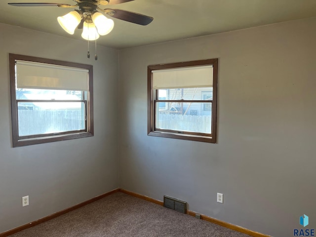spare room with visible vents, baseboards, carpet, and a healthy amount of sunlight