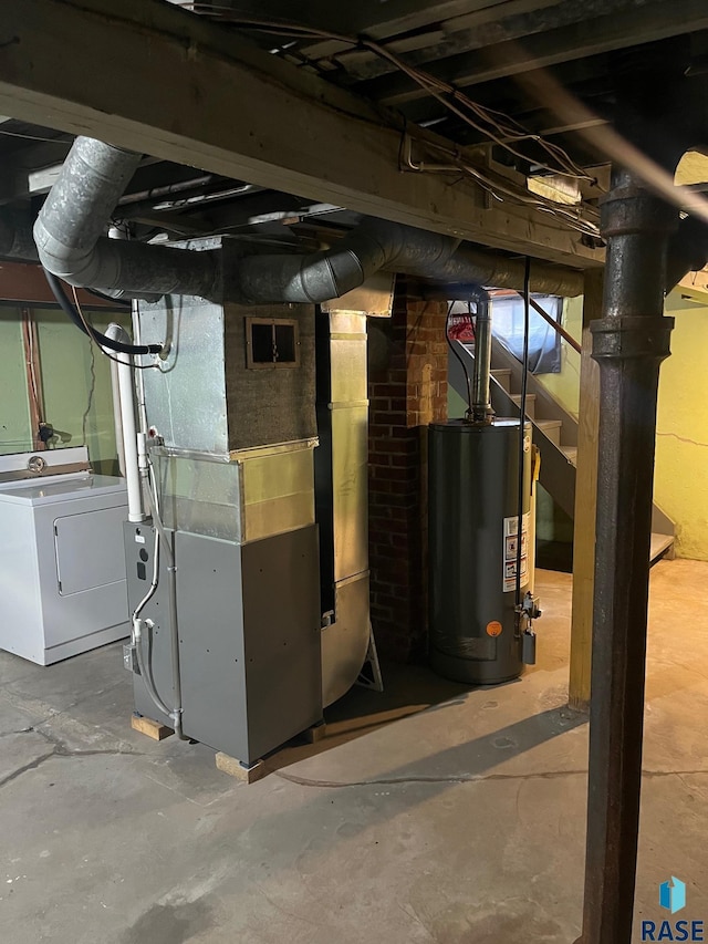 unfinished below grade area with washer / dryer, heating unit, visible vents, and water heater