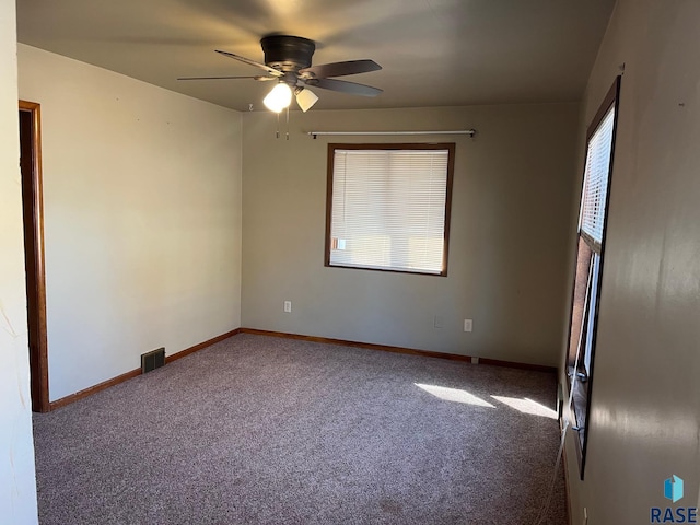 spare room with visible vents, baseboards, carpet floors, and ceiling fan