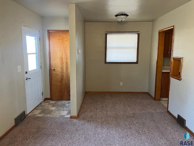 carpeted entryway with visible vents and baseboards