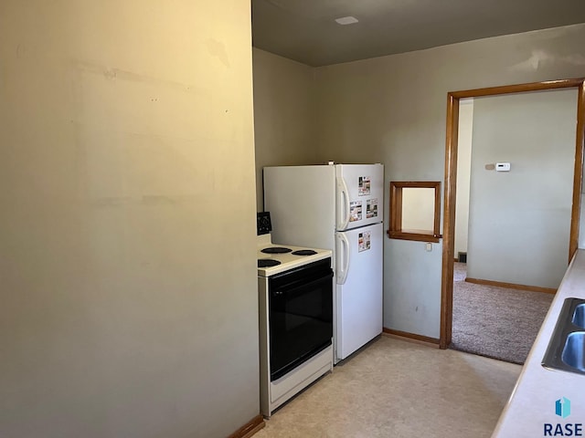 kitchen with baseboards, freestanding refrigerator, a sink, light countertops, and electric stove