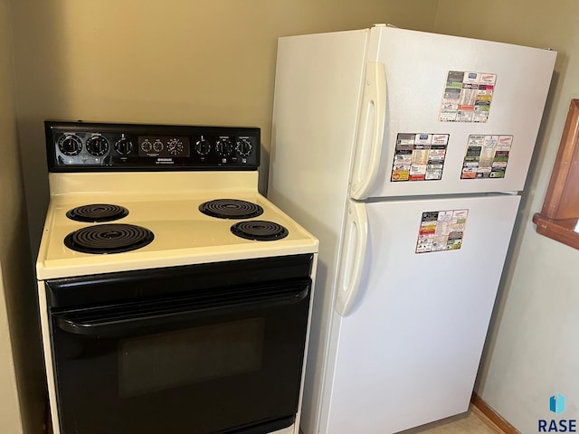 kitchen featuring electric range oven and freestanding refrigerator