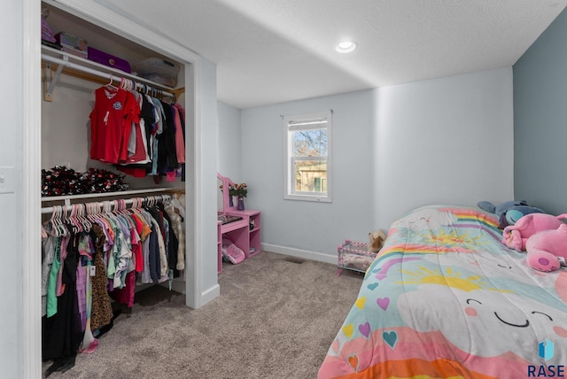 carpeted bedroom with baseboards, a closet, and a textured ceiling