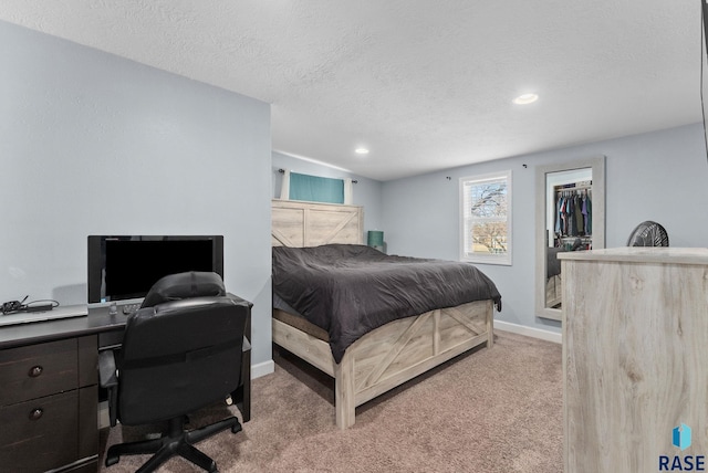 carpeted bedroom with a textured ceiling, recessed lighting, a closet, baseboards, and a spacious closet