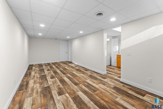 finished below grade area featuring hardwood / wood-style flooring, baseboards, and visible vents