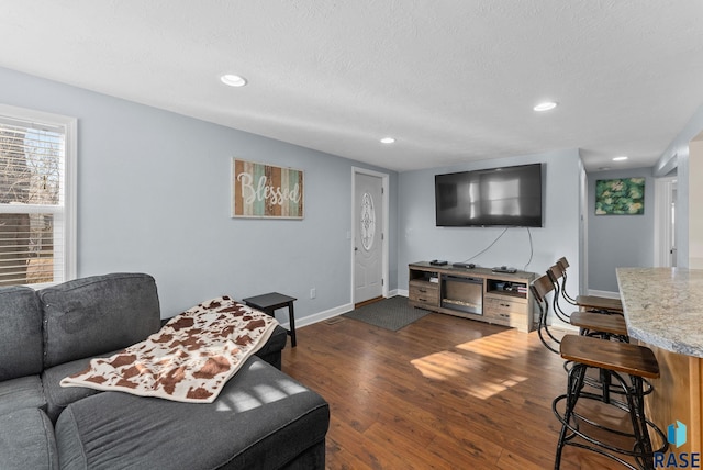 living area featuring recessed lighting, baseboards, and dark wood-style flooring