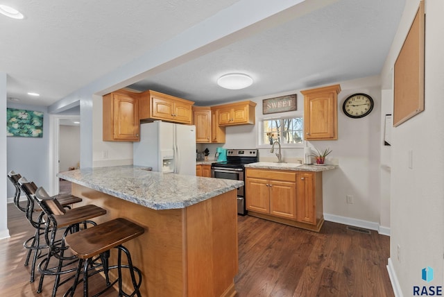 kitchen with a breakfast bar, a peninsula, stainless steel electric stove, a sink, and white fridge with ice dispenser