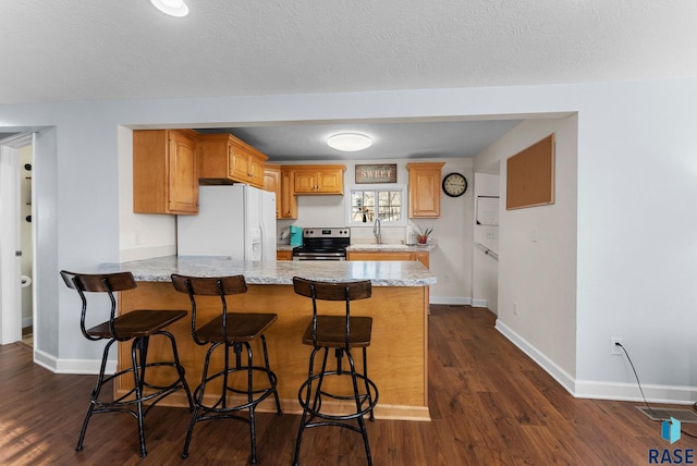 kitchen featuring stainless steel electric range oven, white refrigerator with ice dispenser, a peninsula, and dark wood-style flooring