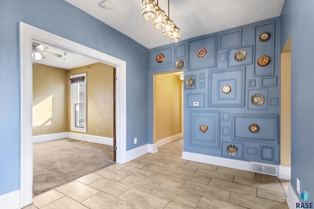 unfurnished room featuring light carpet, baseboards, visible vents, and ceiling fan