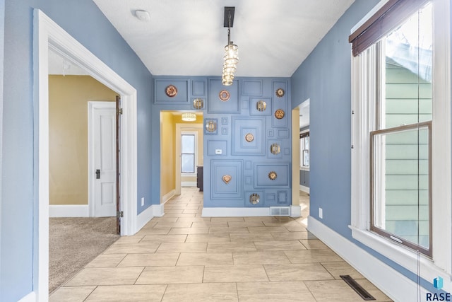 unfurnished room featuring plenty of natural light, baseboards, and visible vents