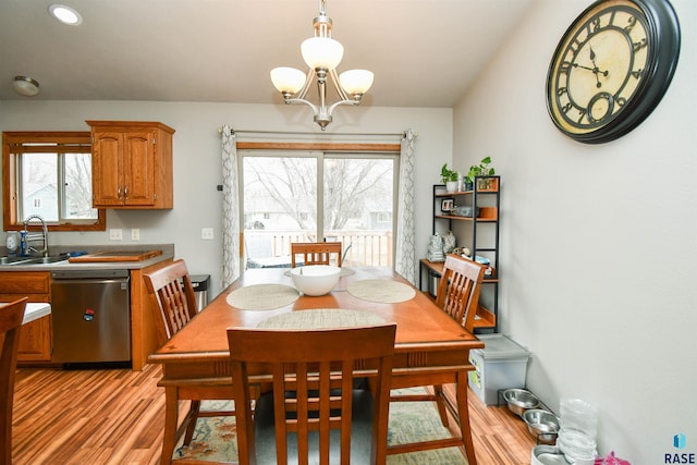 dining room with light wood-type flooring and an inviting chandelier