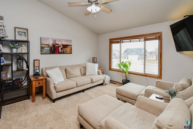 living room with baseboards, vaulted ceiling, a ceiling fan, and light colored carpet