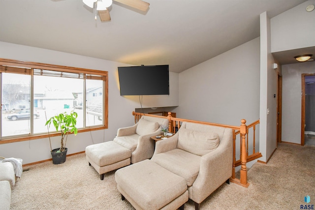 living area with a ceiling fan, carpet floors, an upstairs landing, and baseboards