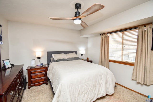 bedroom with light carpet, baseboards, and a ceiling fan