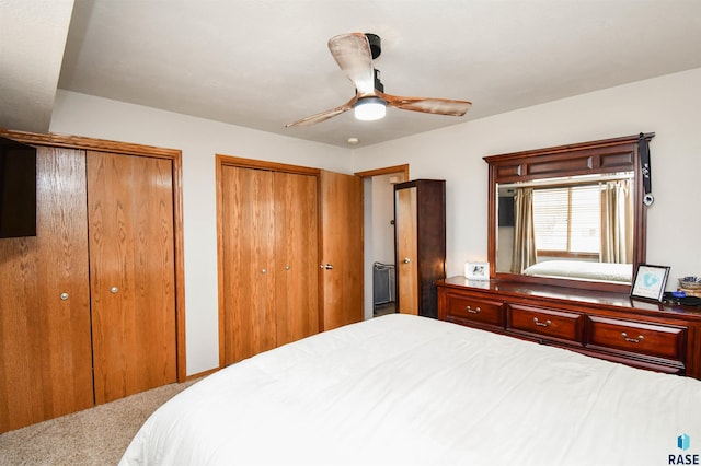 bedroom with multiple closets, ceiling fan, and carpet floors