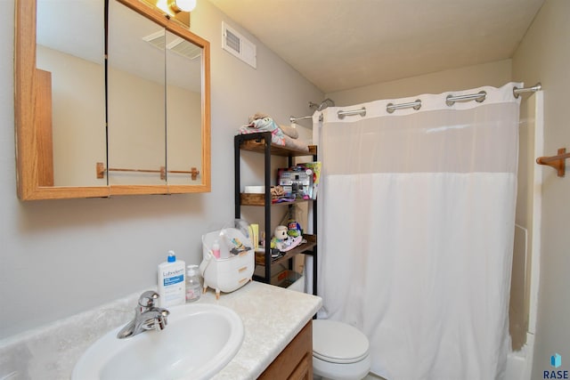 bathroom featuring visible vents, toilet, and vanity