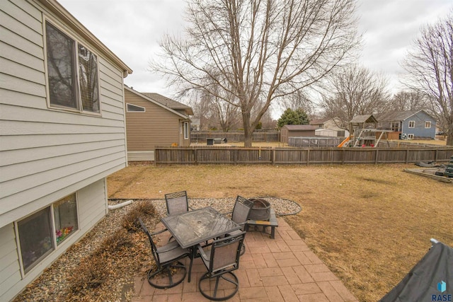 view of yard with fence, outdoor dining area, a patio area, and a playground
