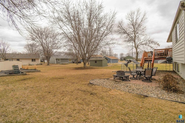 view of yard featuring a fire pit, a wooden deck, and a patio area